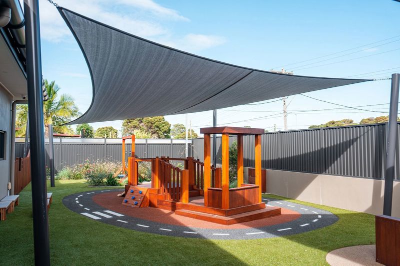 KOSS 2021 — kindergarten outdoor play area with shade sail and timber cubby