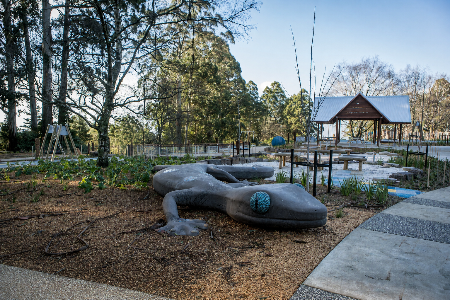 Parks Victoria / SRV Projects — sculptural lizard play element with pavilion beyond
